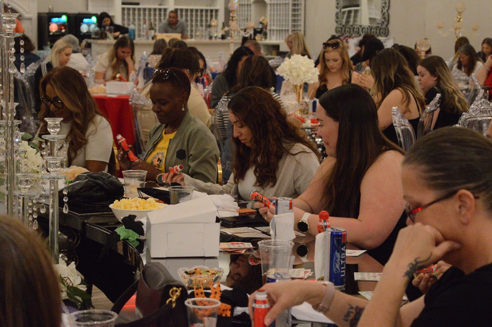 A large group of people are sitting at tables at a party.