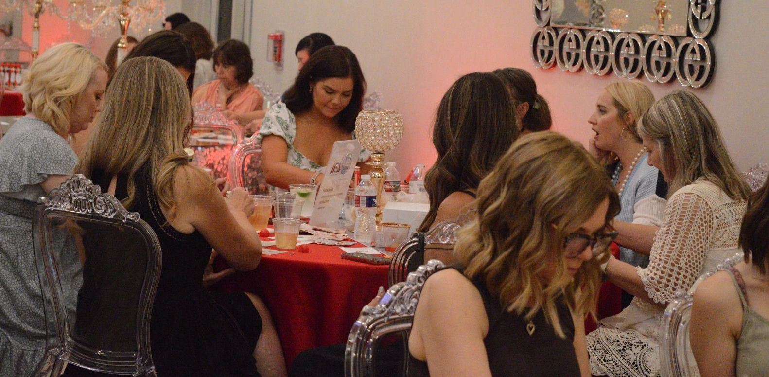 A group of women are sitting at tables at a party.