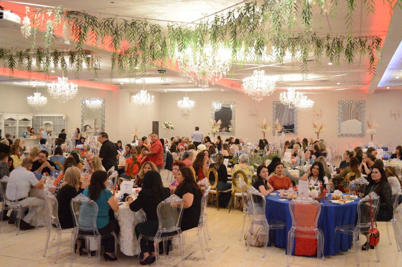 A large group of people are sitting at tables in a large room.
