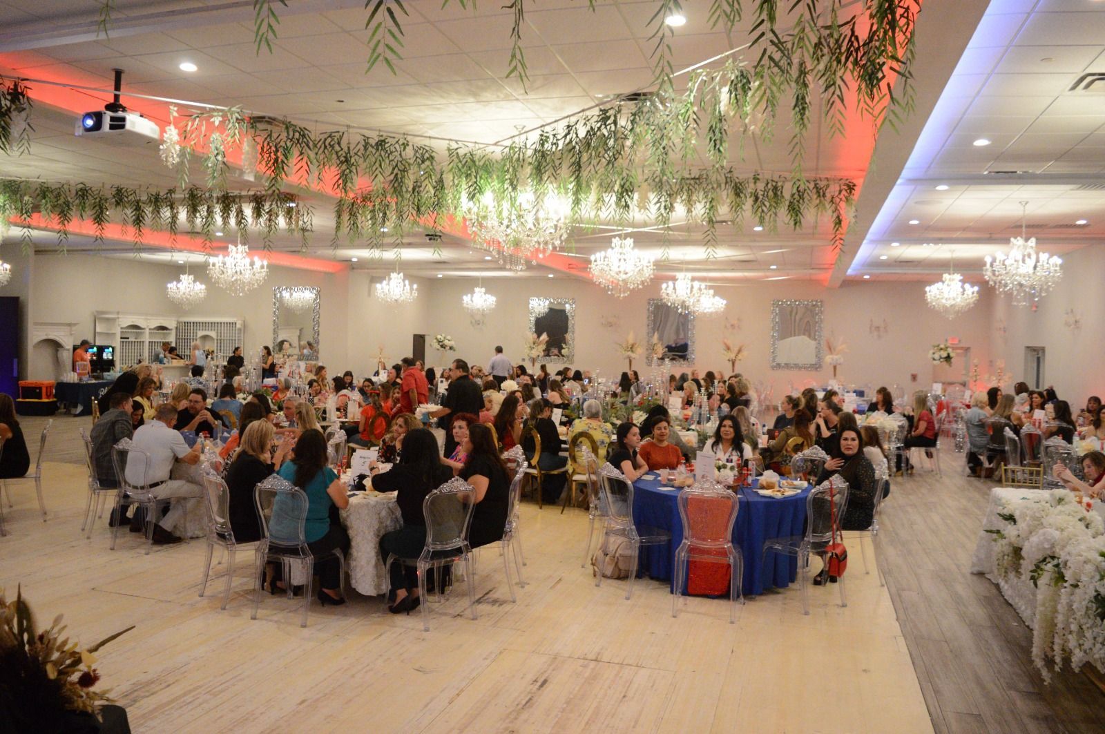 A large room filled with people sitting at tables and chairs.