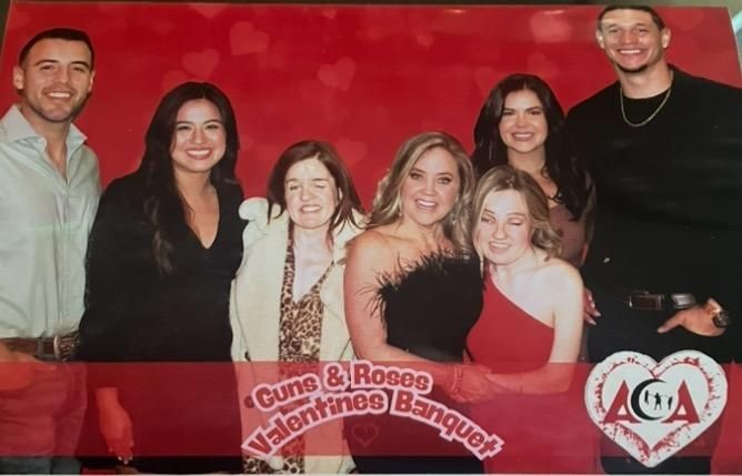 A group of people are posing for a picture at a valentine 's banquet