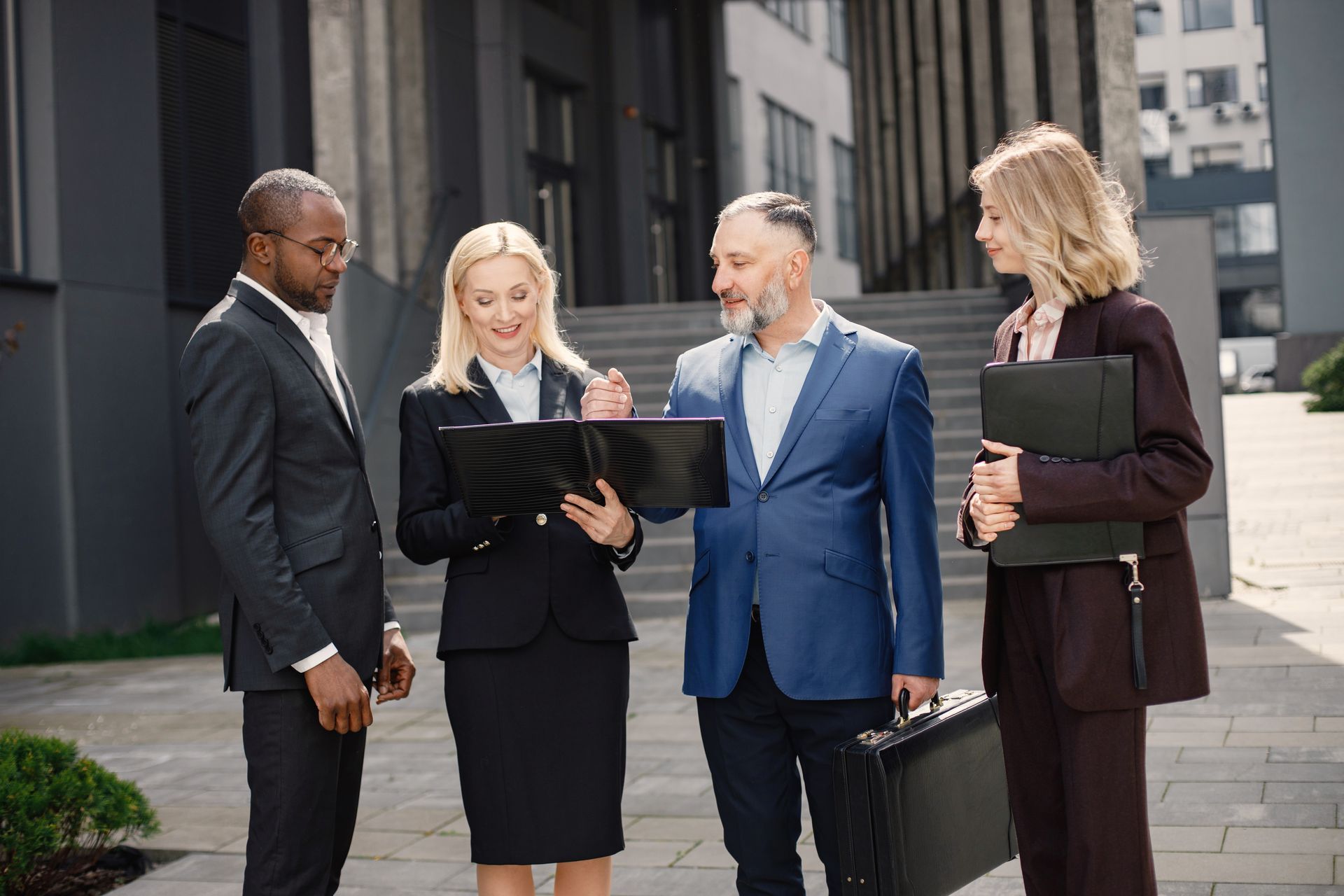 A group of business people are standing next to each other in front of a building.