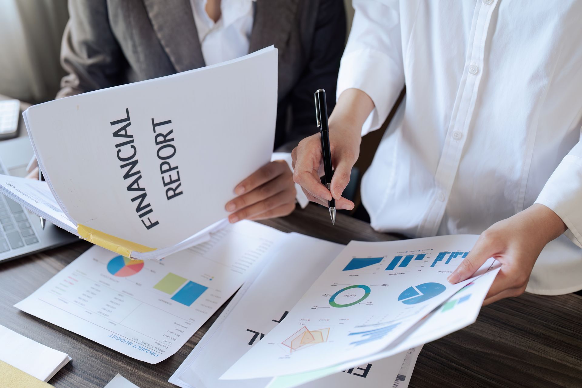Two people are sitting at a table looking at a financial report.