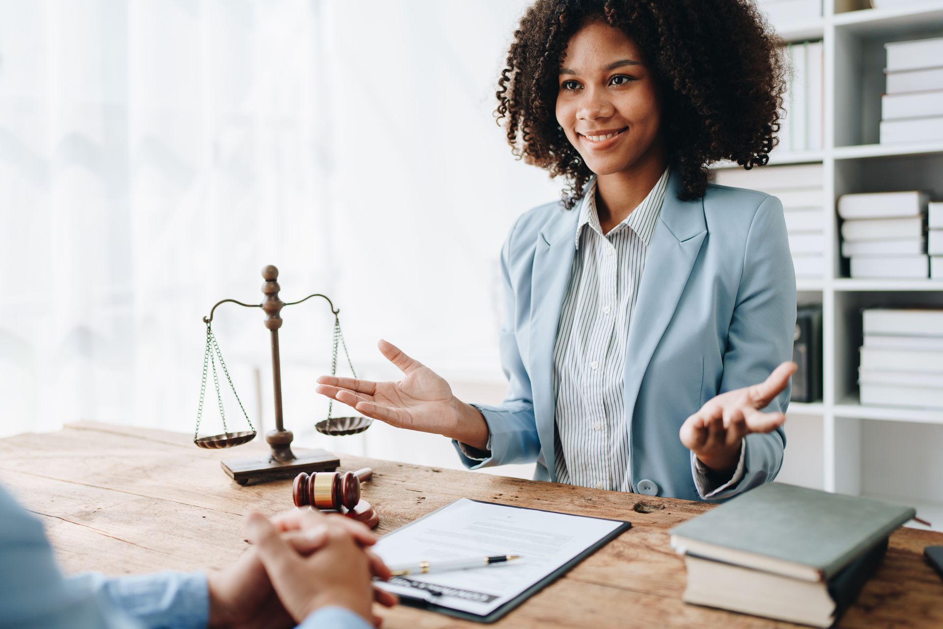 A woman is sitting at a table talking to a man.
