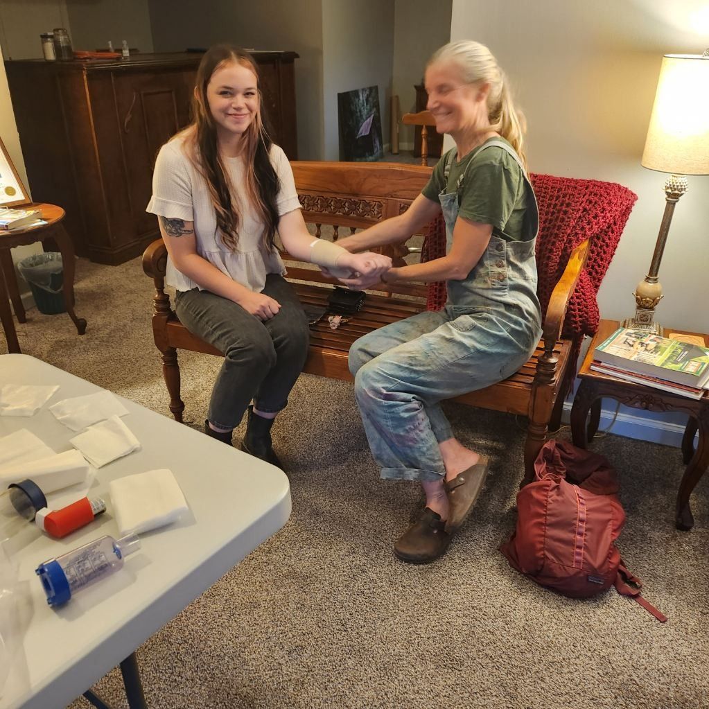 Two people sitting together on a couch, smiling and holding hands in a cozy living room.