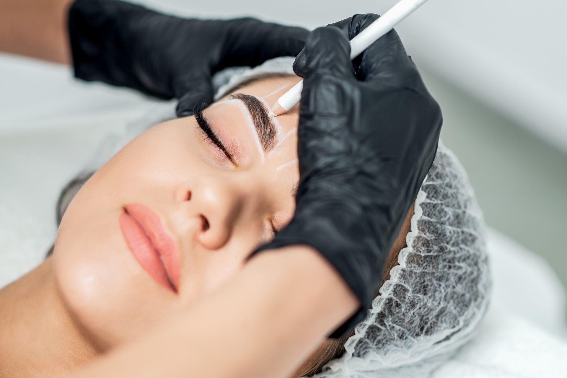 Eine Frau lässt sich in einem Schönheitssalon die Augenbrauen machen.