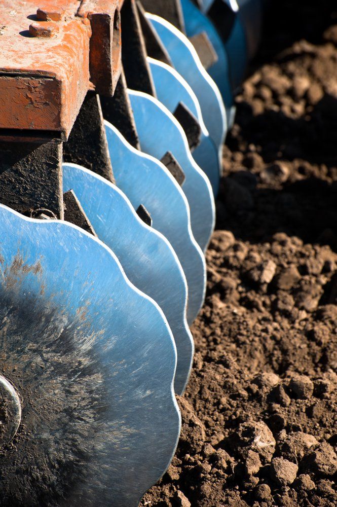 Disk Harrow Sitting In Plowed Soil — Tractor Repairs in North Lismore, NSW