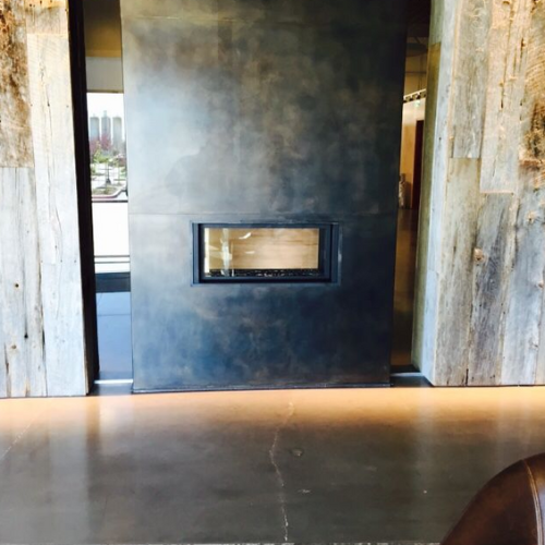 A living room with a fireplace in the middle of the wall