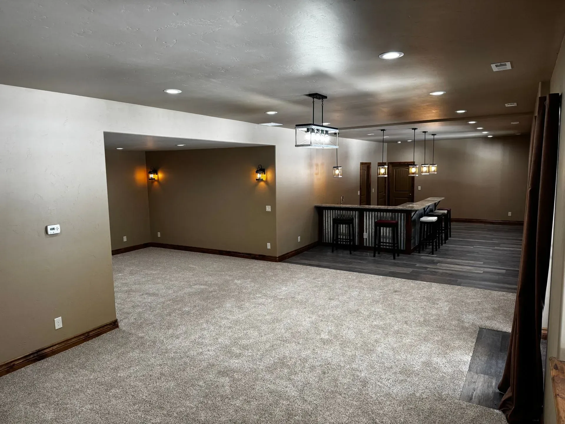 Finished basement with bar, carpet, recessed lighting, and a dark bar.