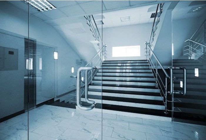 Glass Business glazed doors in front of steps entering into a office building.