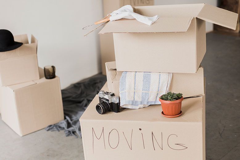 A stack of cardboard boxes with the word moving written on them.