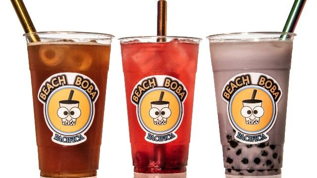 Three cups of beach bora drinks with straws in them