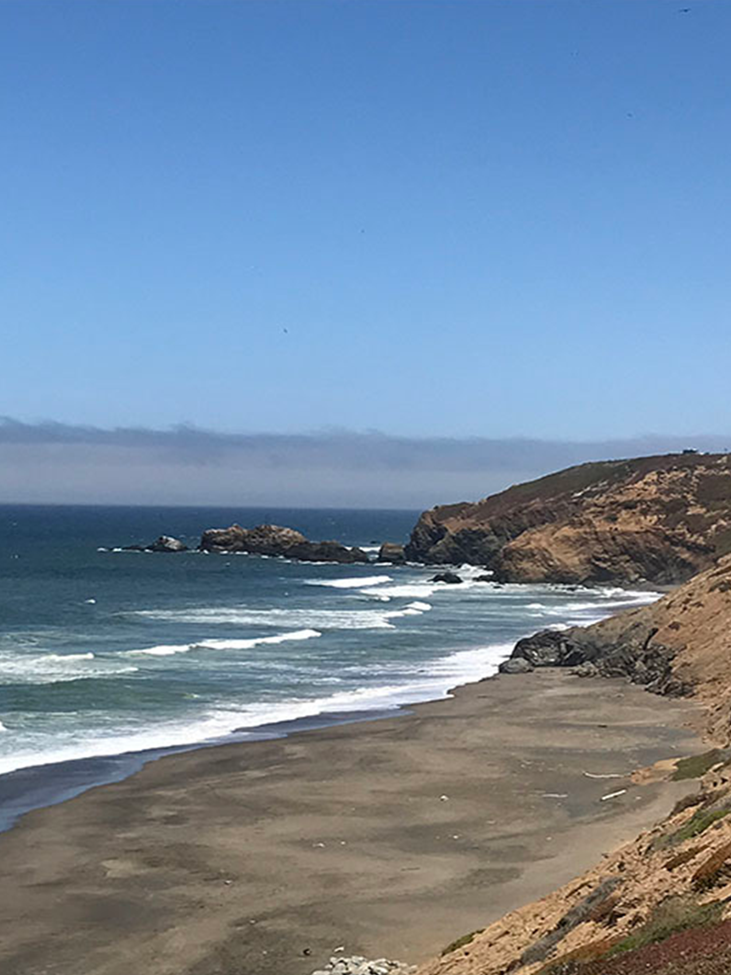 A beach with waves coming in on a sunny day