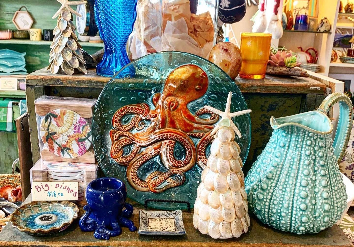 A table with a plate with an octopus on it and a pitcher.