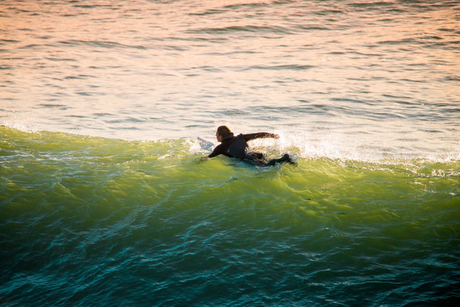 A man is riding a wave on a surfboard in the ocean.