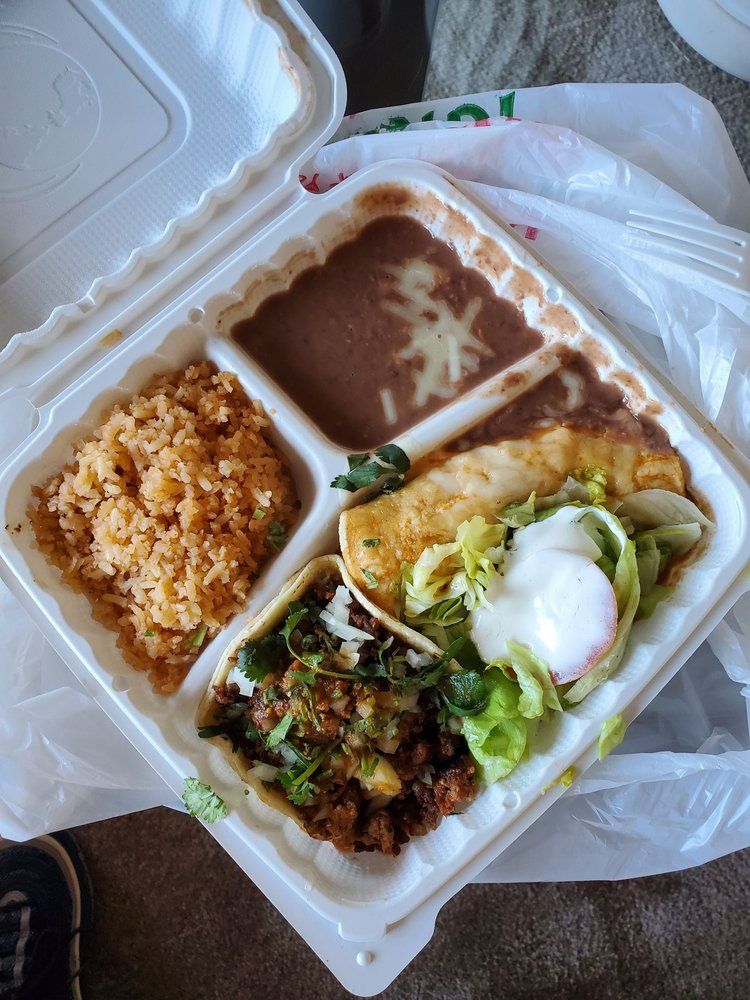 A styrofoam container filled with rice beans and tacos.