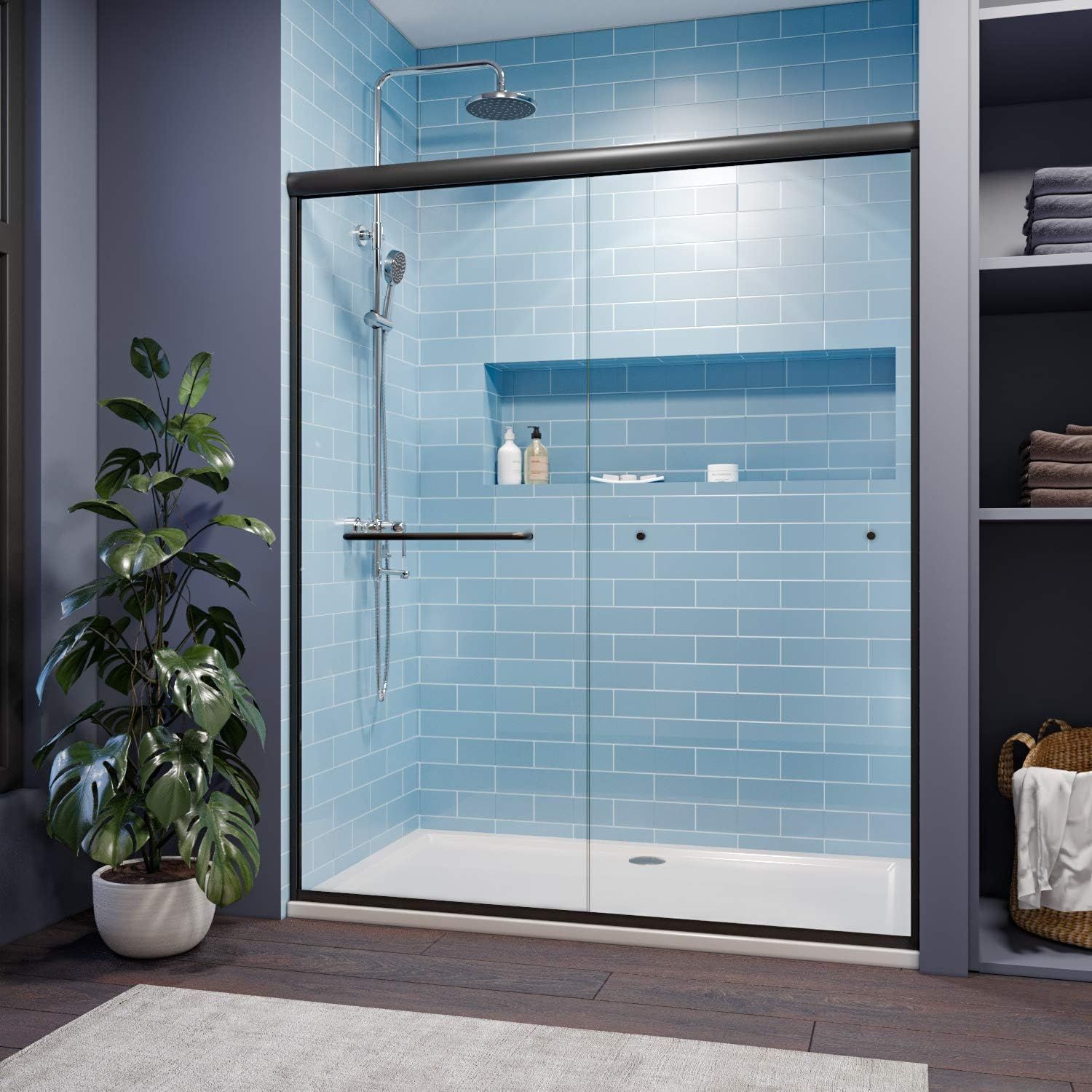 A bathroom with blue tiles and a sliding glass shower door.