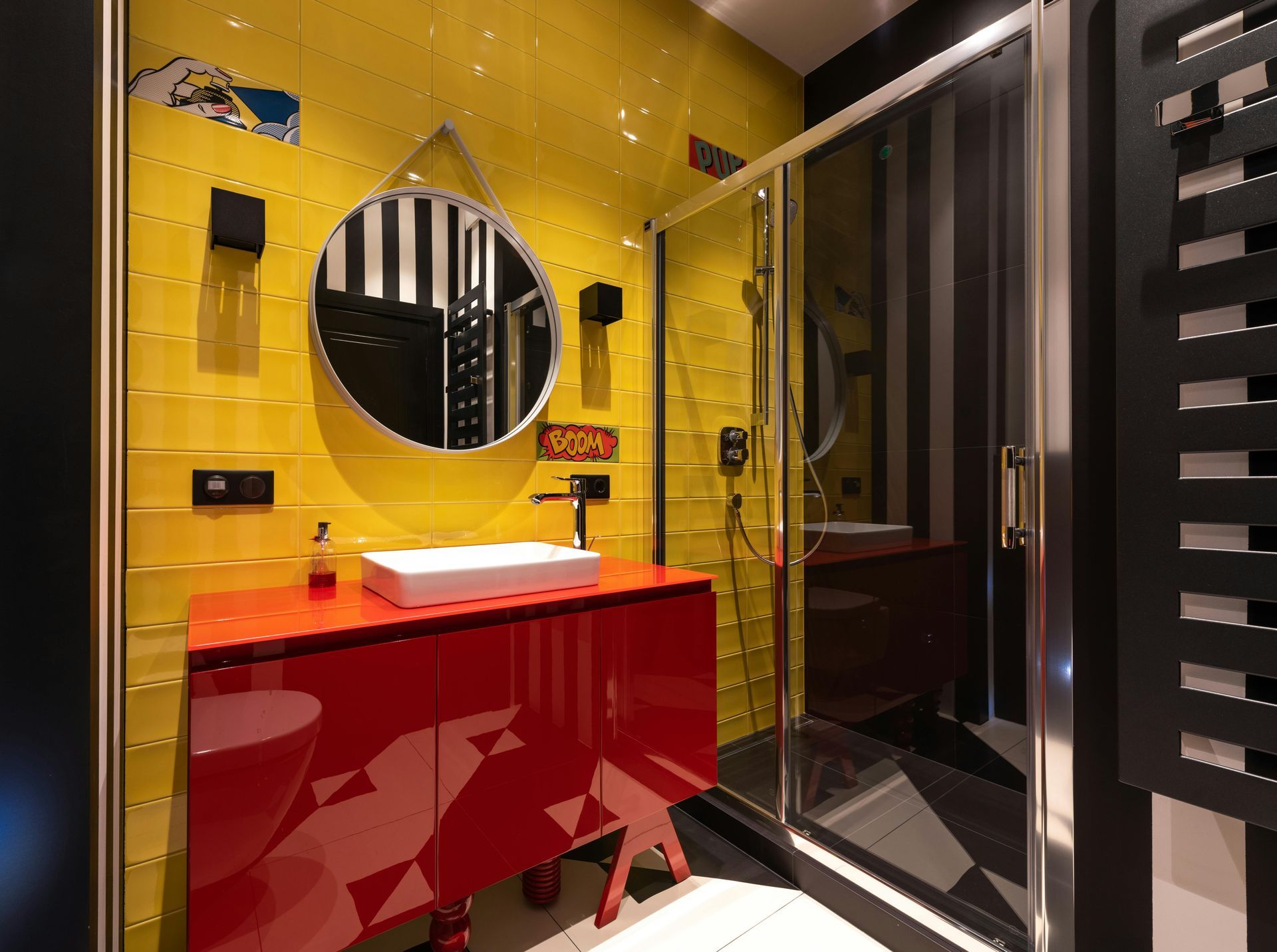 A bathroom with yellow tiles , red cabinets , a sink and a shower.