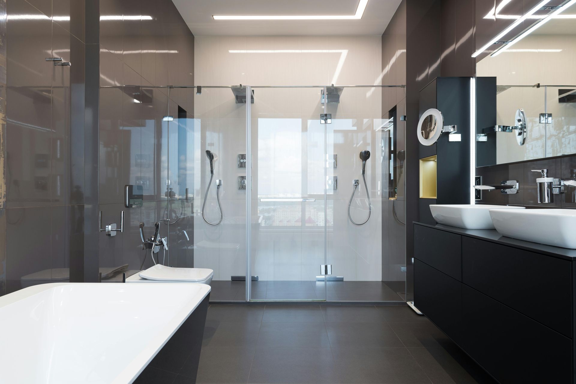 Modern bathroom with gray walls, glass shower, black vanity with sinks, and a bathtub.
