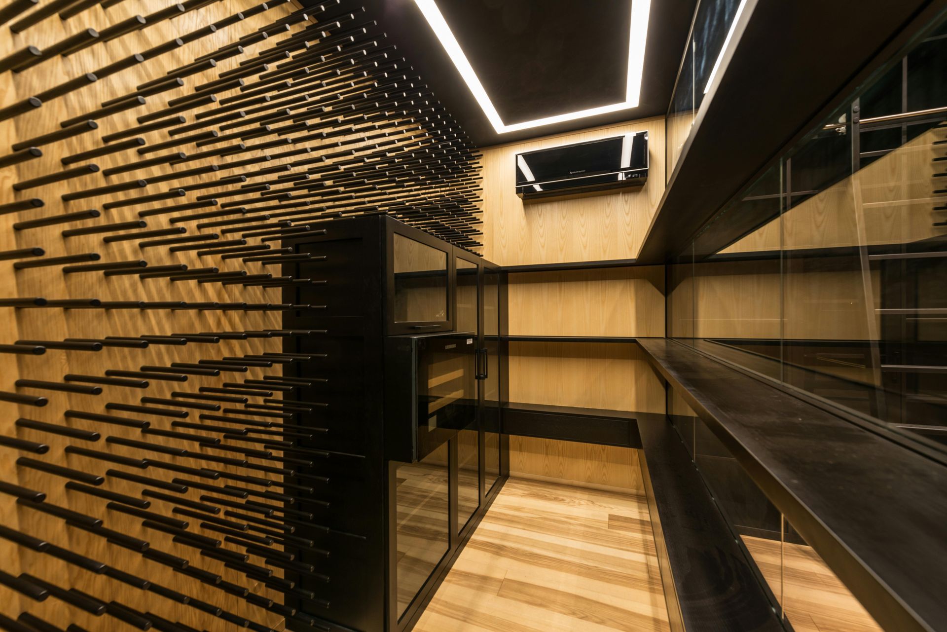 Modern wine cellar with wooden walls, black shelves, and wine bottle storage.