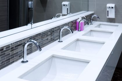 A bathroom with three sinks and a large mirror