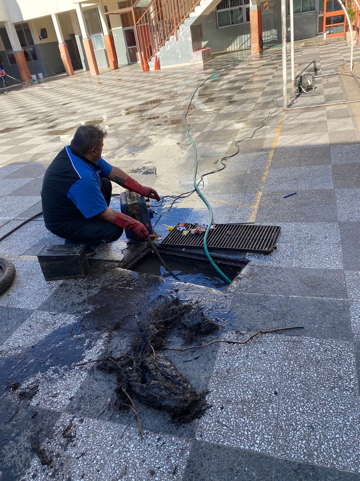 Un trabajador utiliza una máquina para reparar el pavimento dañado de una acera de la ciudad