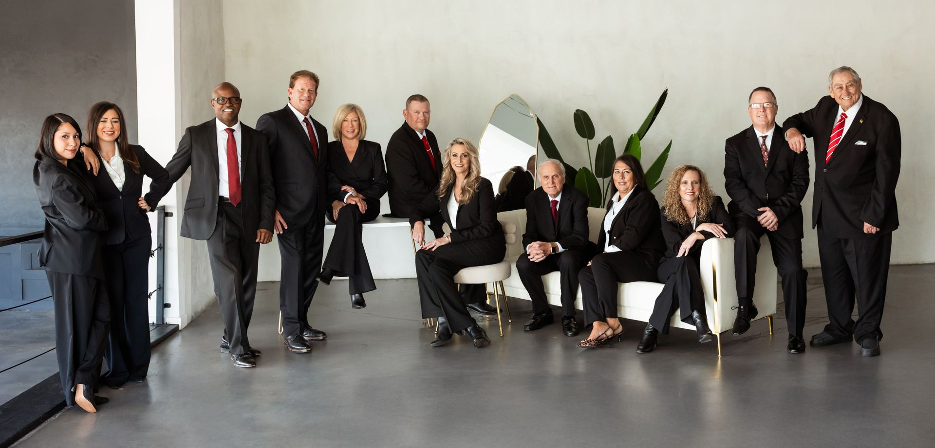 Group of people in business attire posing for a formal portrait in a studio setting
