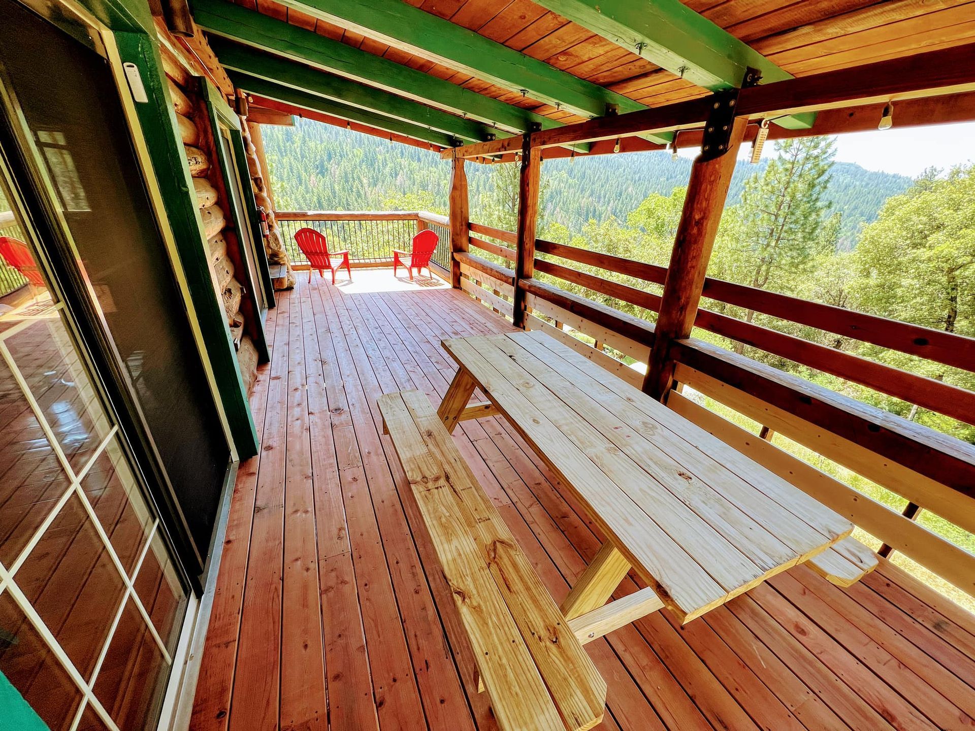 Italian Bar Cabin Exterior deck and balcony with a wood bench and two red chairs at the far end corner.