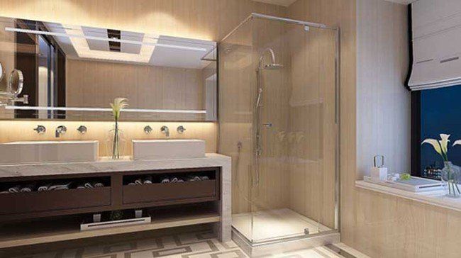 Modern bathroom featuring a double vanity, a glass-enclosed shower, warm lighting, and a view through a large window.