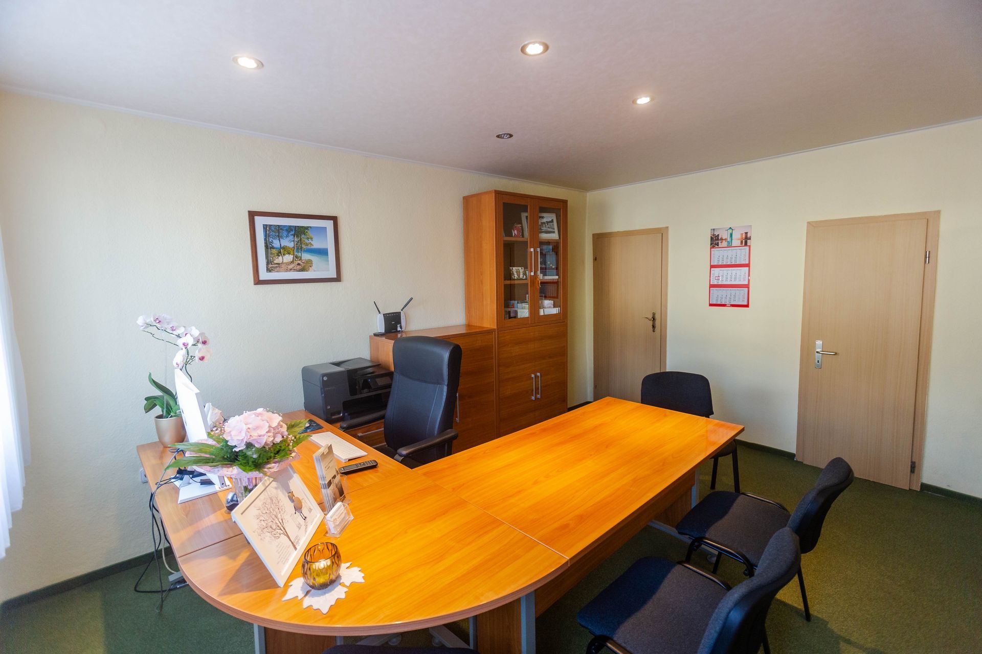 Büro Bestattungshaus Schuldt mit einem großen Holzschreibtisch, einem Ledersessel und einem Aktenschrank. 