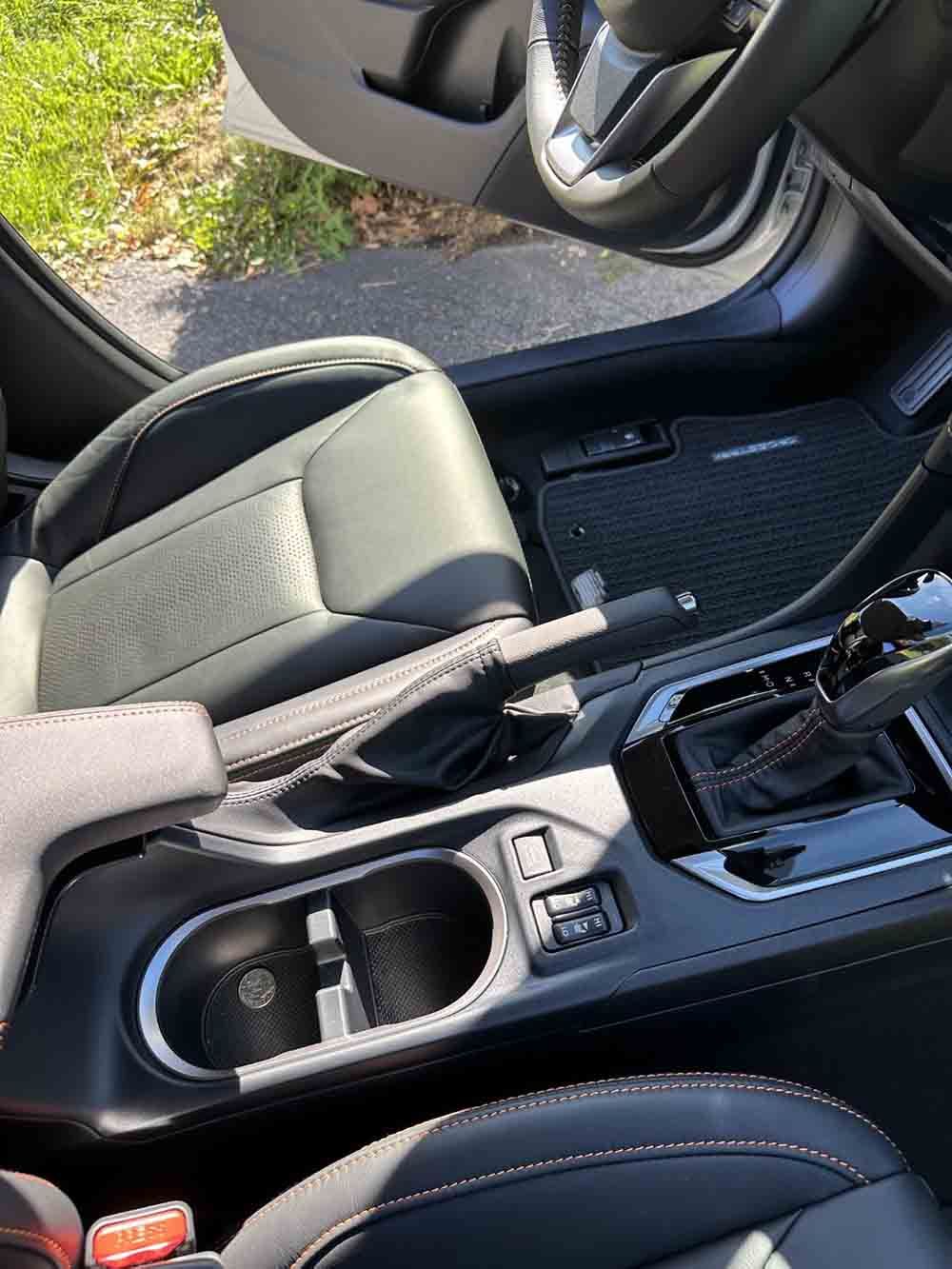a car with the door open and a cup holder in the center console