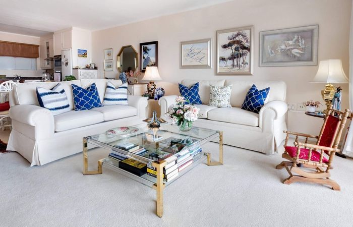 a living room with two white couches and a rocking chair