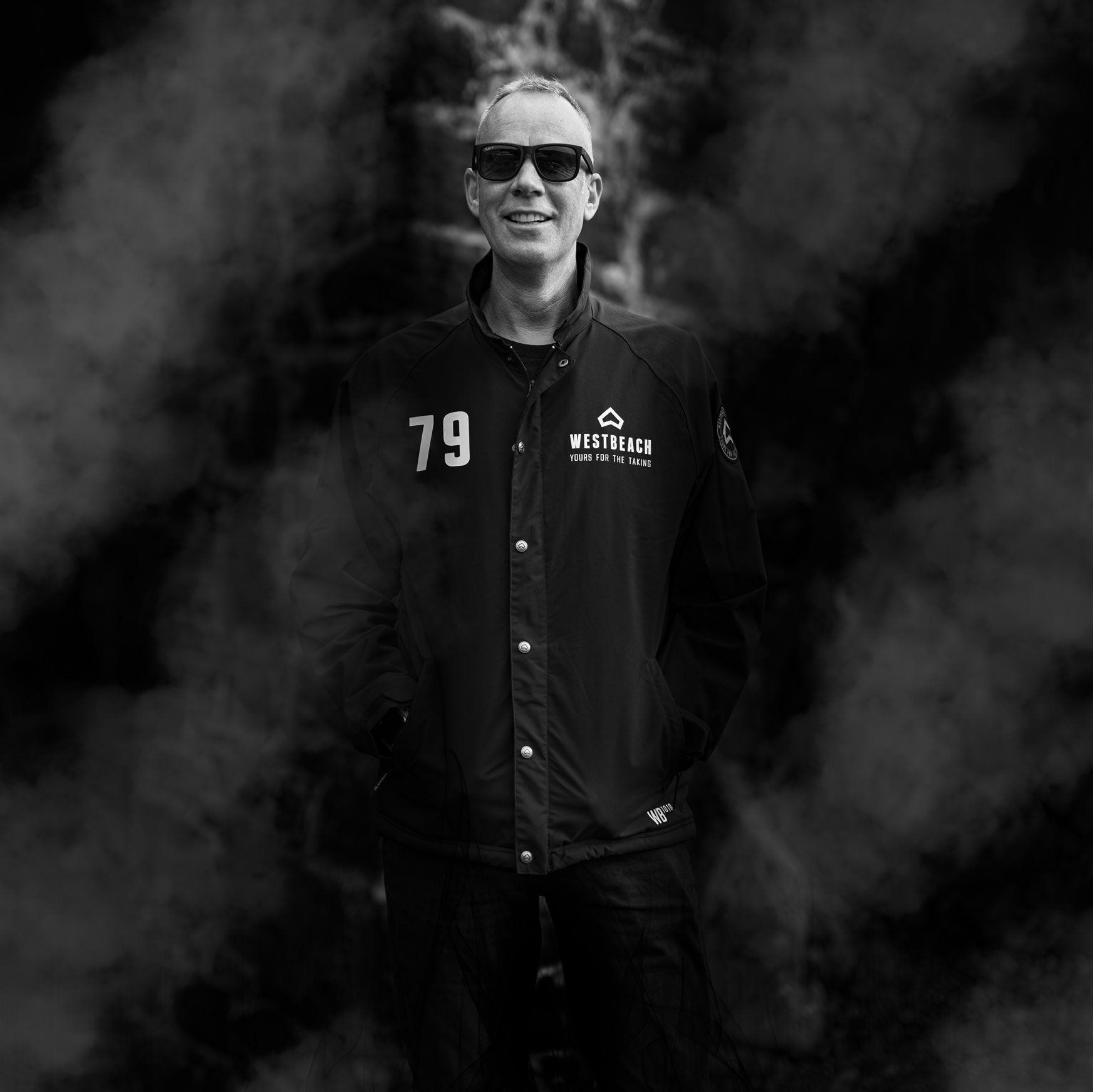 A man wearing sunglasses and a jacket with the number 79 on it