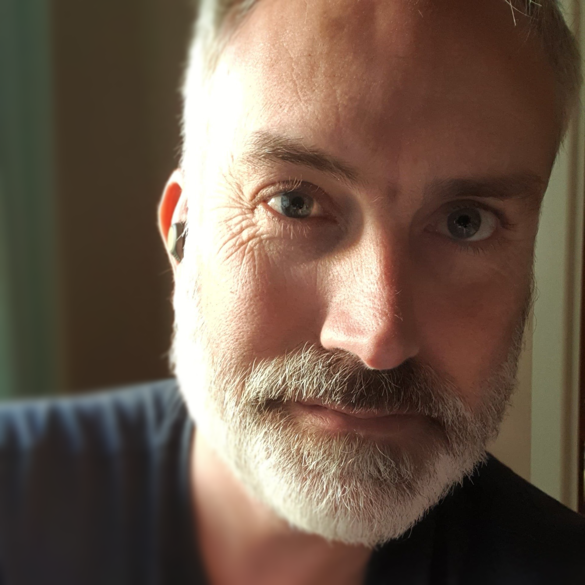 A close up of a man 's face with a beard