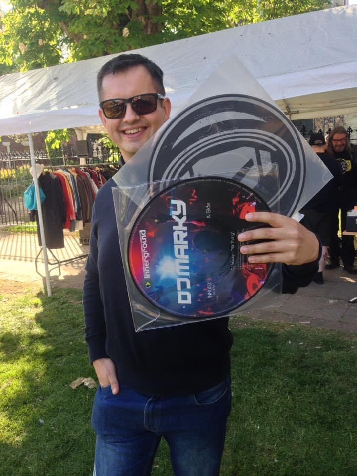 A man wearing sunglasses is holding a disc that says omarky on it
