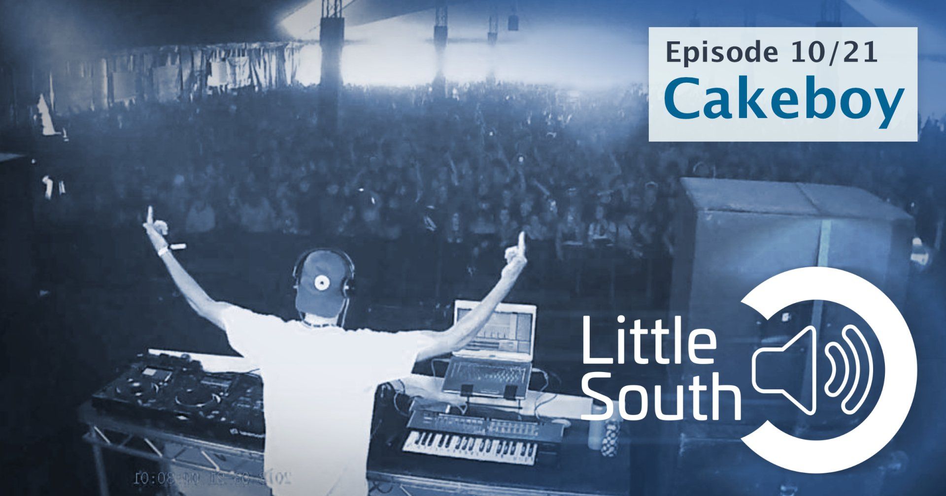 A man stands in front of a crowd with his arms outstretched and the words little south cakeboy above him