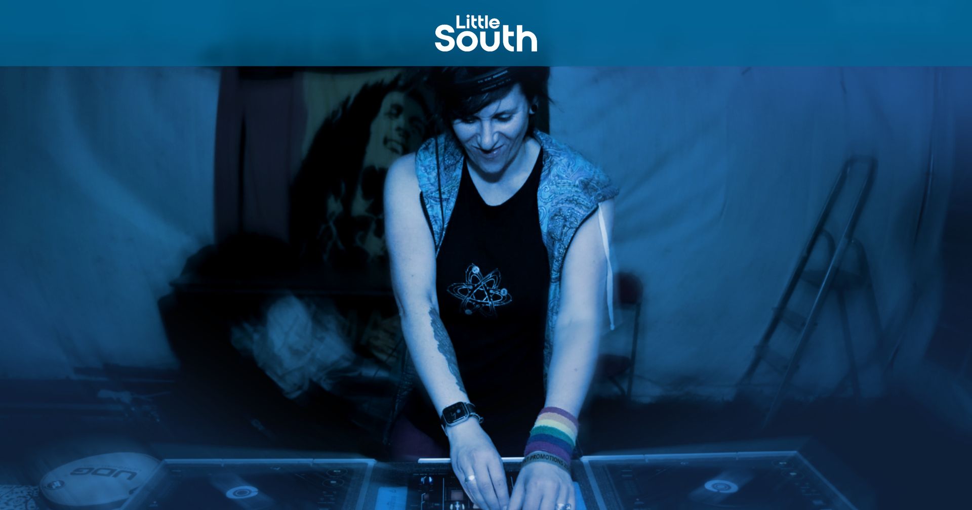 DJ Lady Vix credit to Magg Photography A woman is playing a dj set in a dark room.