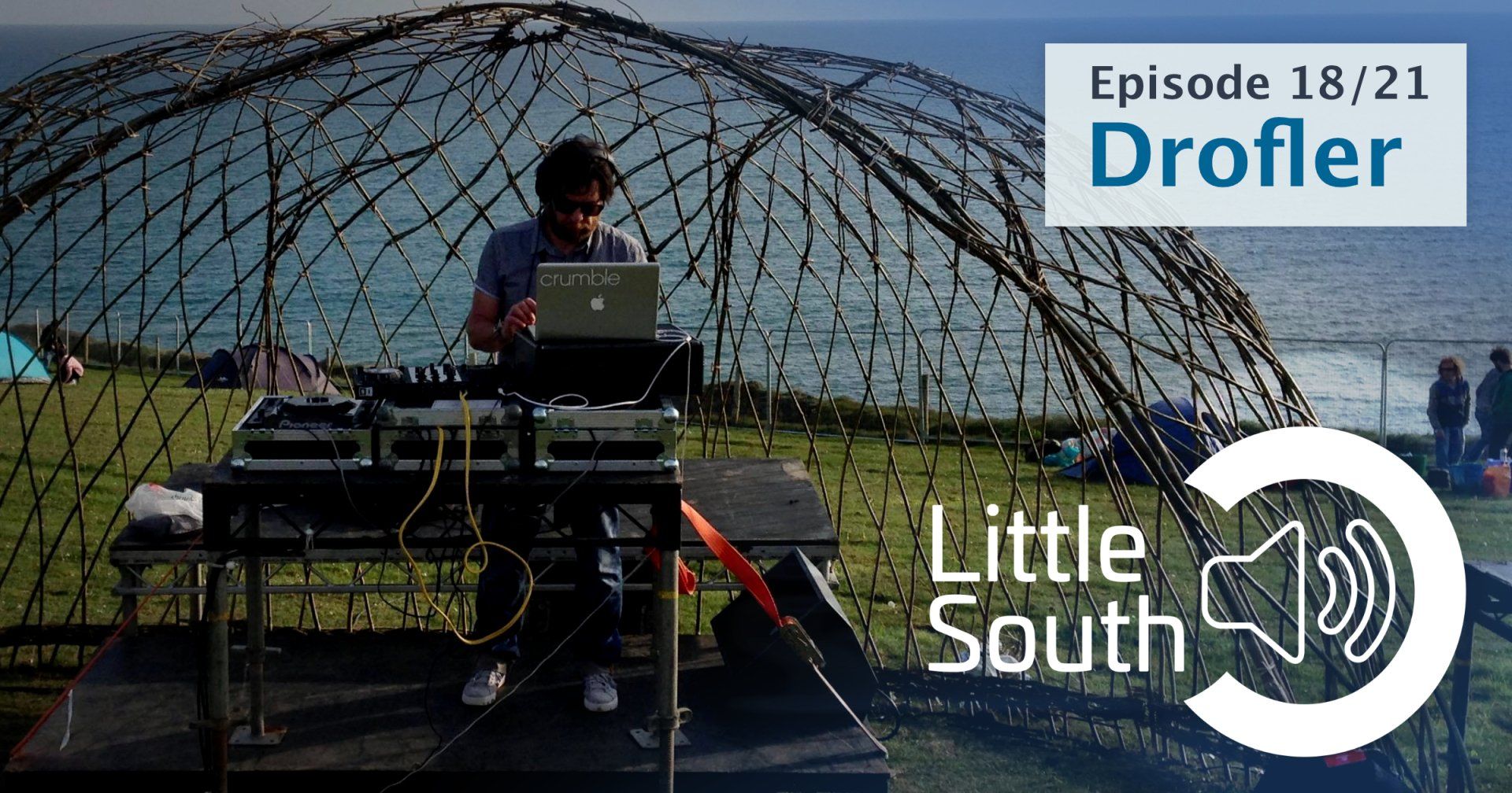 A man sitting at a table with a laptop and the words little south on the bottom