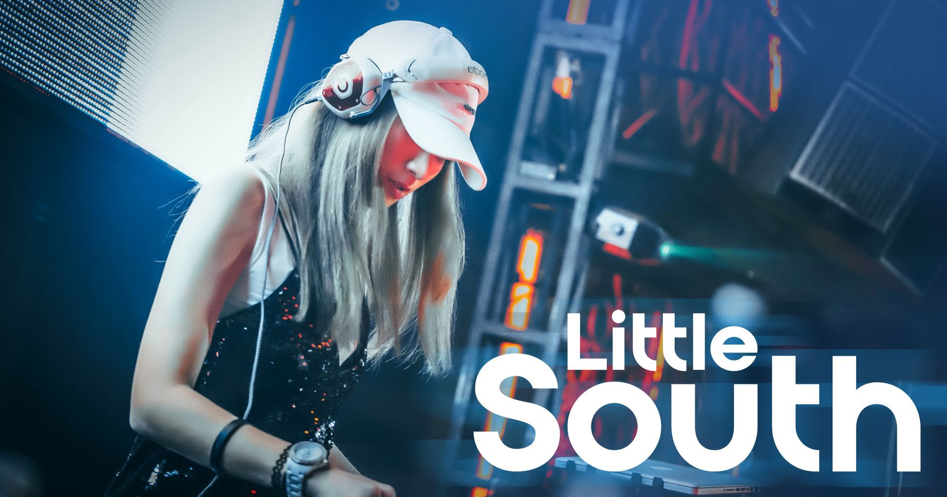 A woman wearing headphones and a hat is playing a dj set.