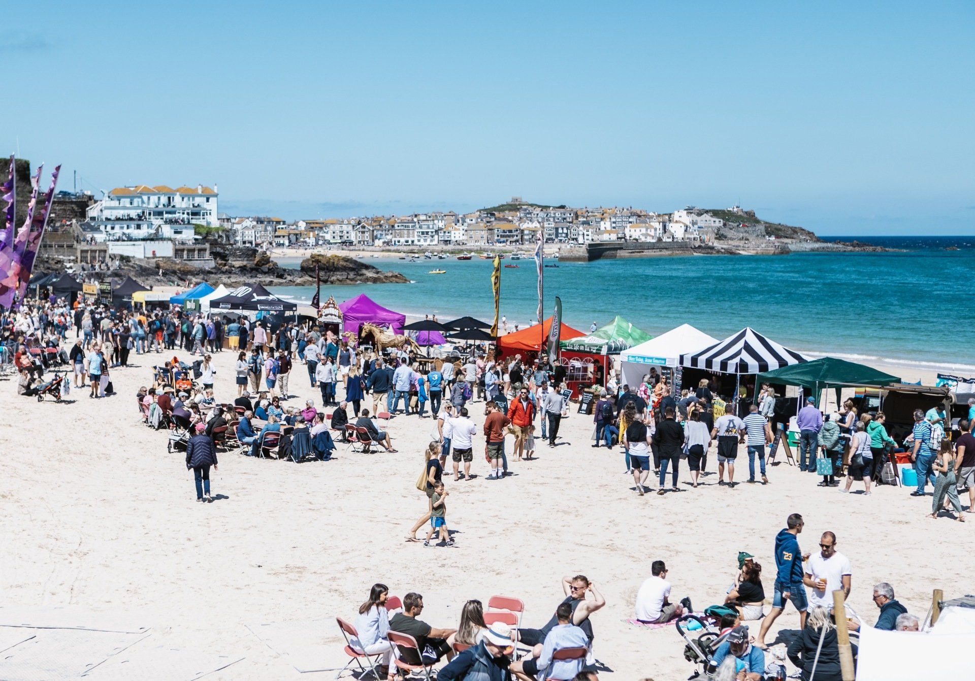 A large group of people are gathered on a beach.