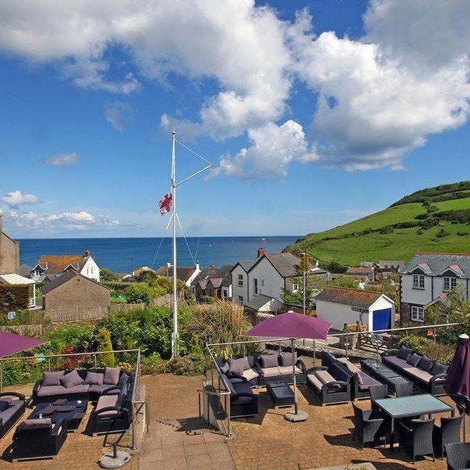 A view of the ocean from a patio with purple umbrellas