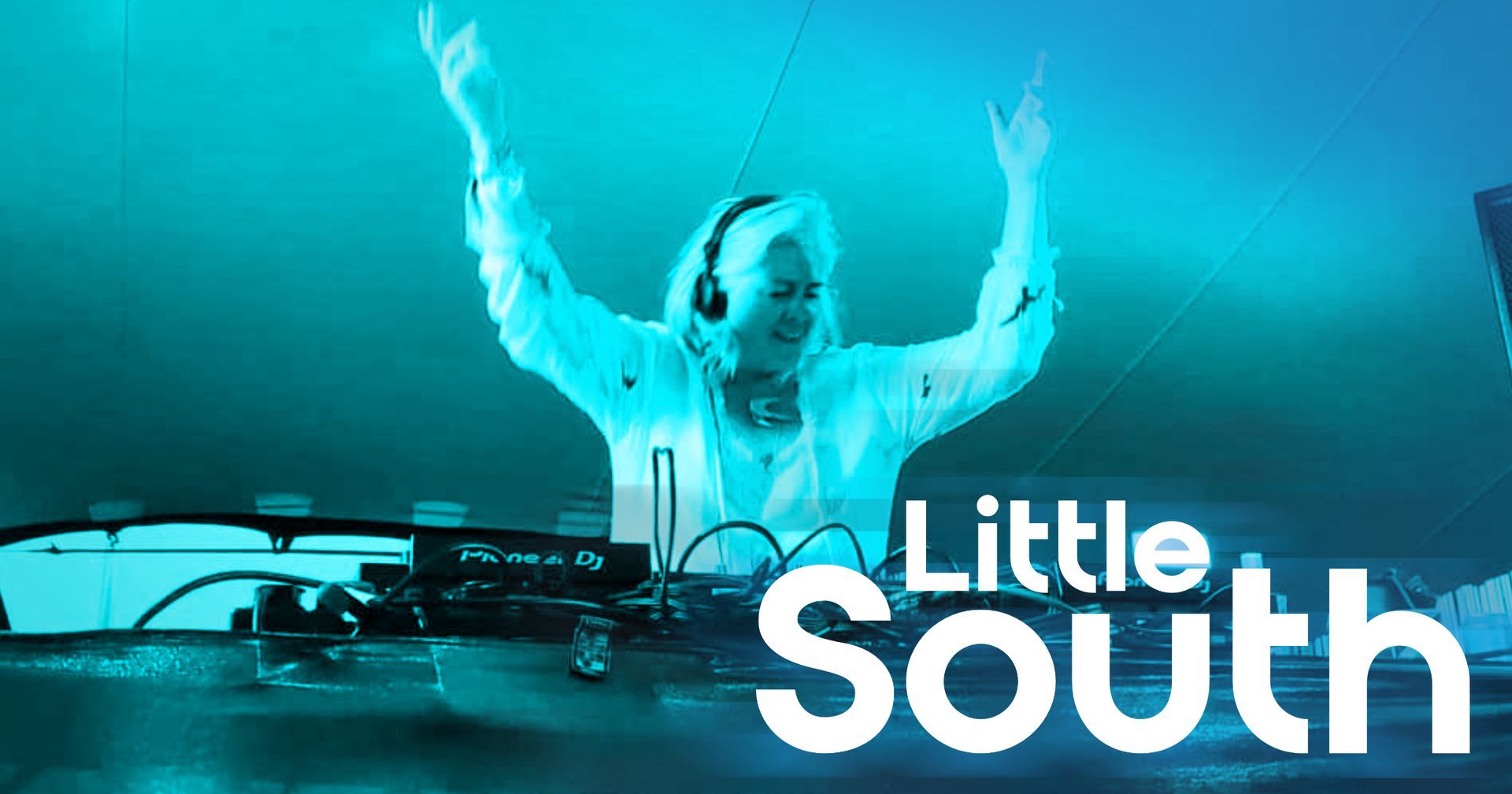 A woman wearing headphones is standing in front of a little south sign.