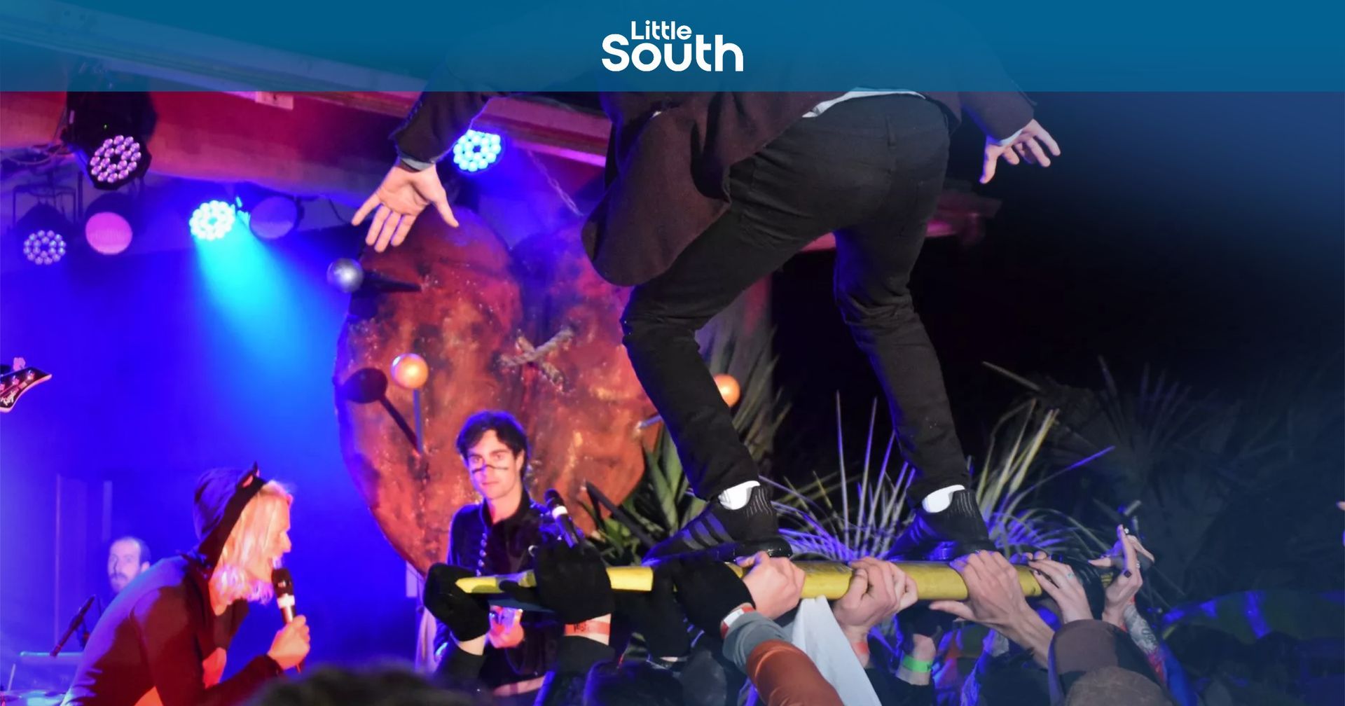 A group of people are dancing on a stage in front of a crowd.