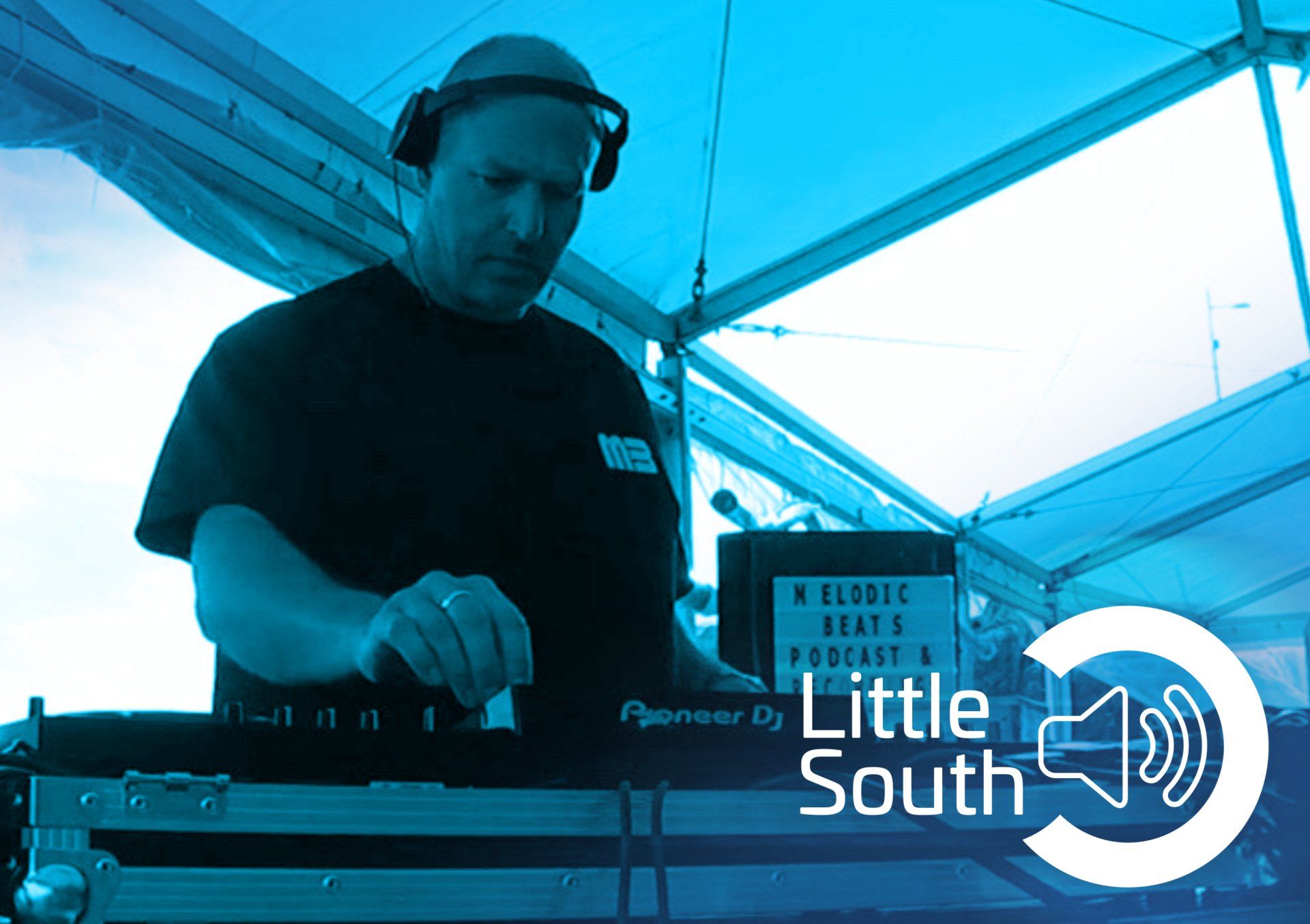 A man wearing headphones is playing music on a pioneer dj