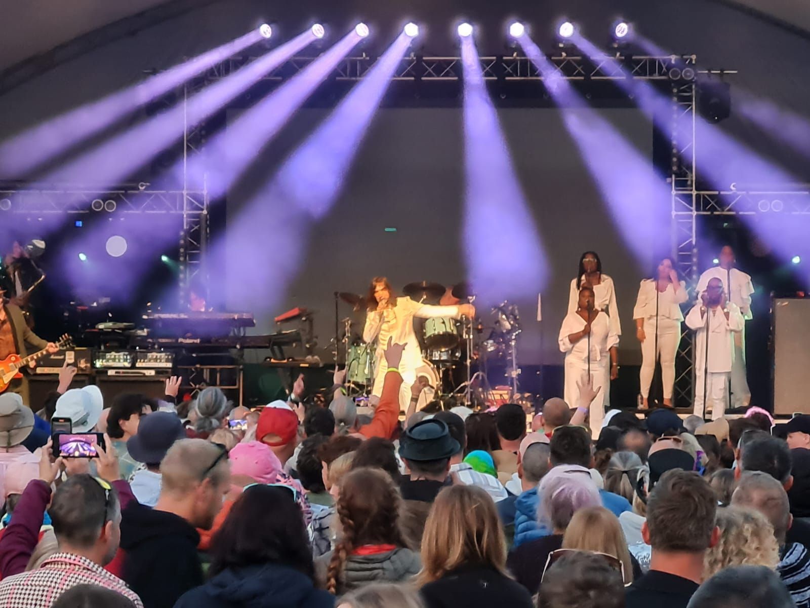 A group of people are standing on a stage in front of a crowd.
