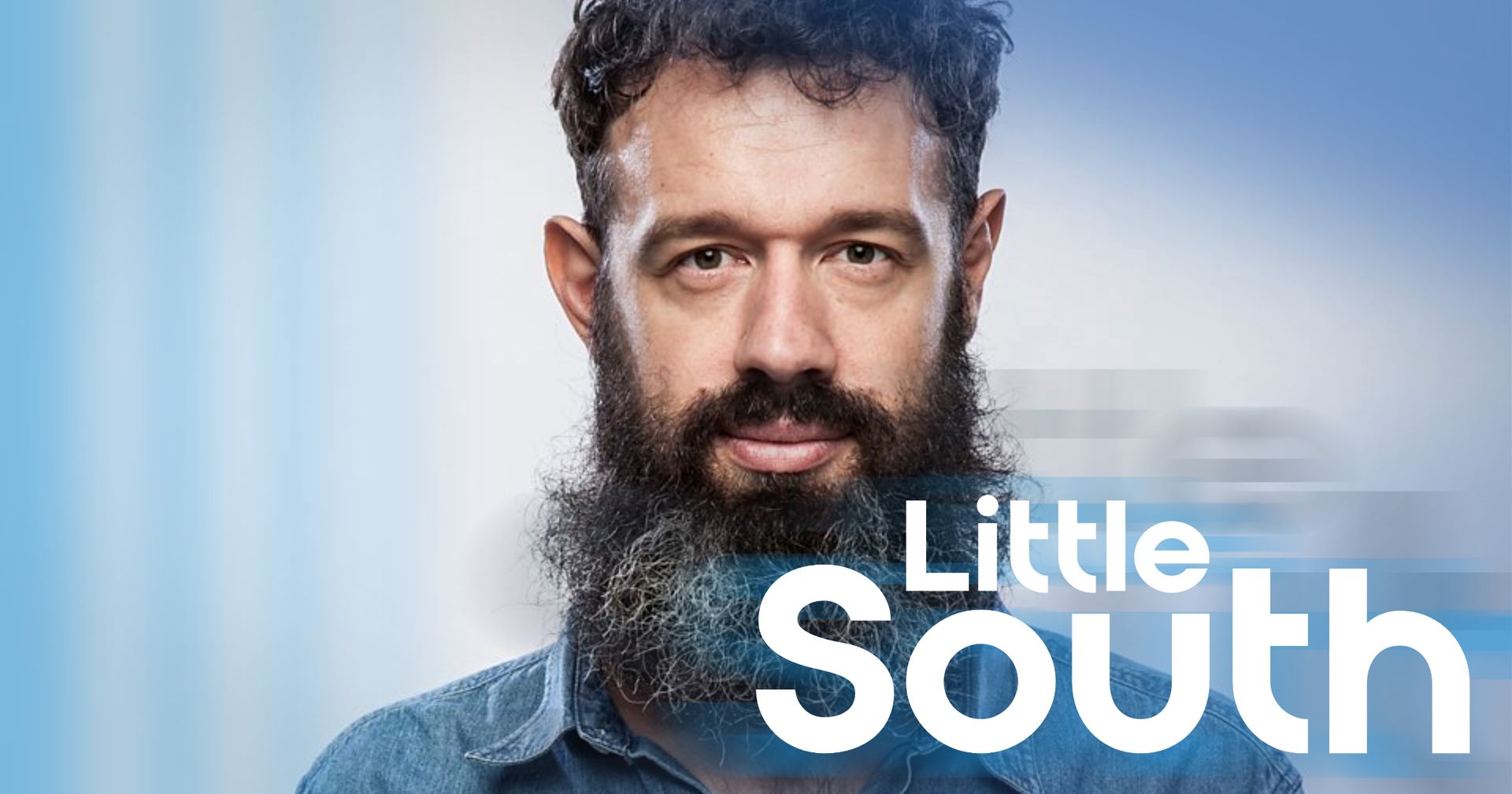 A man with a beard is standing in front of a blue background.