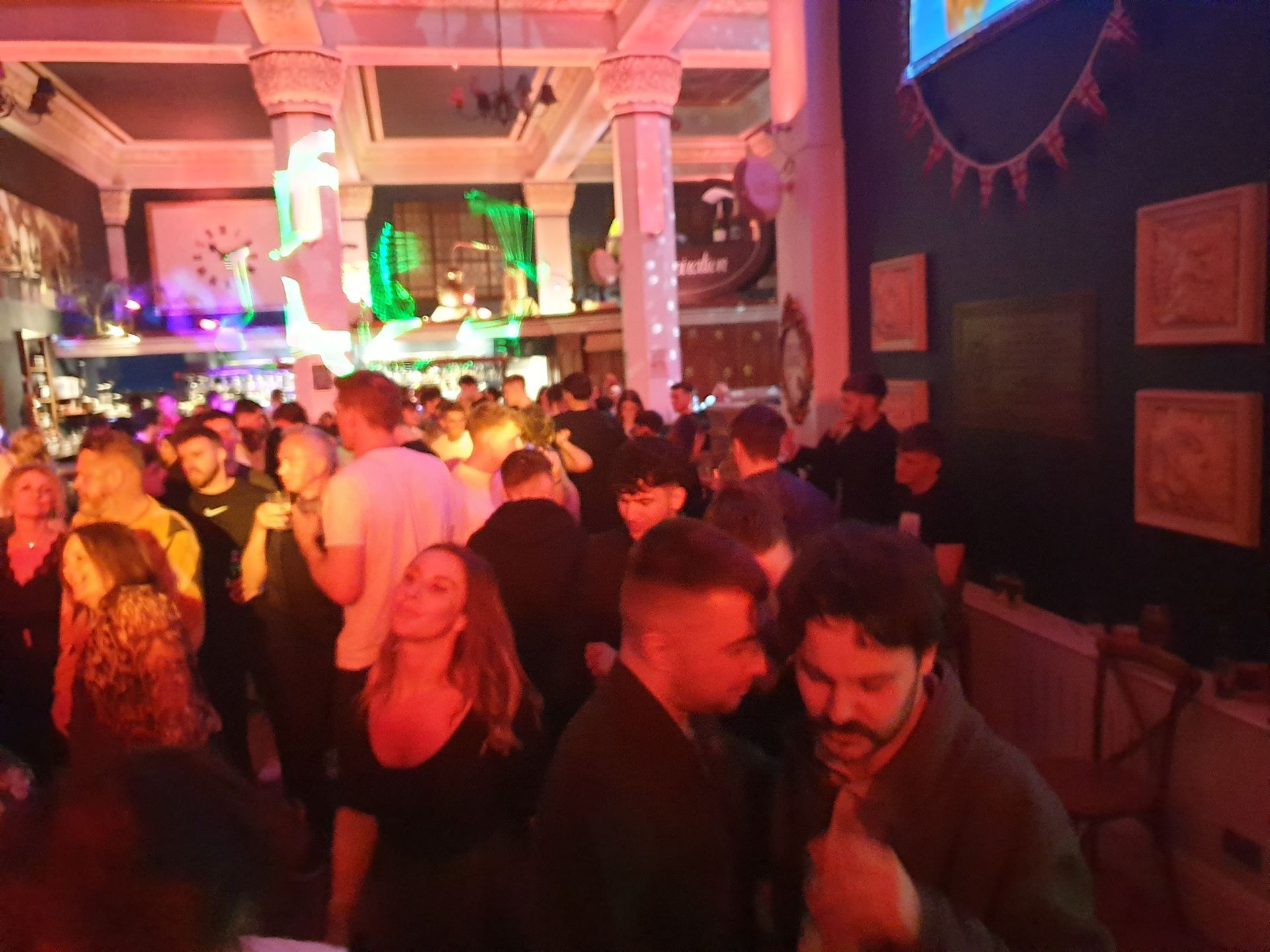 A crowd of people are dancing in a dark room.