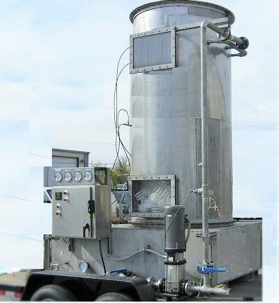 A large stainless steel tank is sitting on top of a trailer.