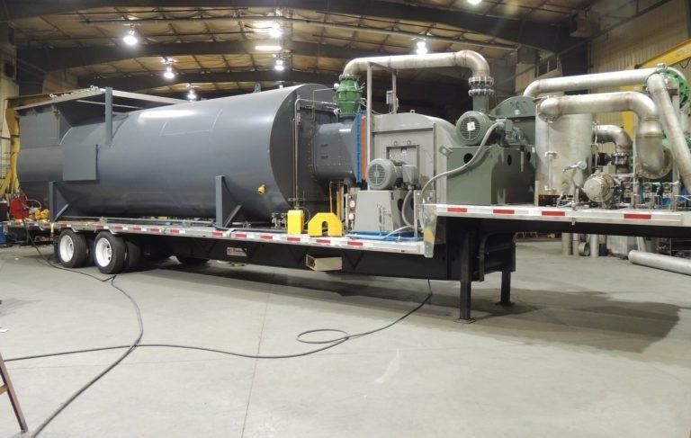 A large machine is sitting on a trailer in a factory.