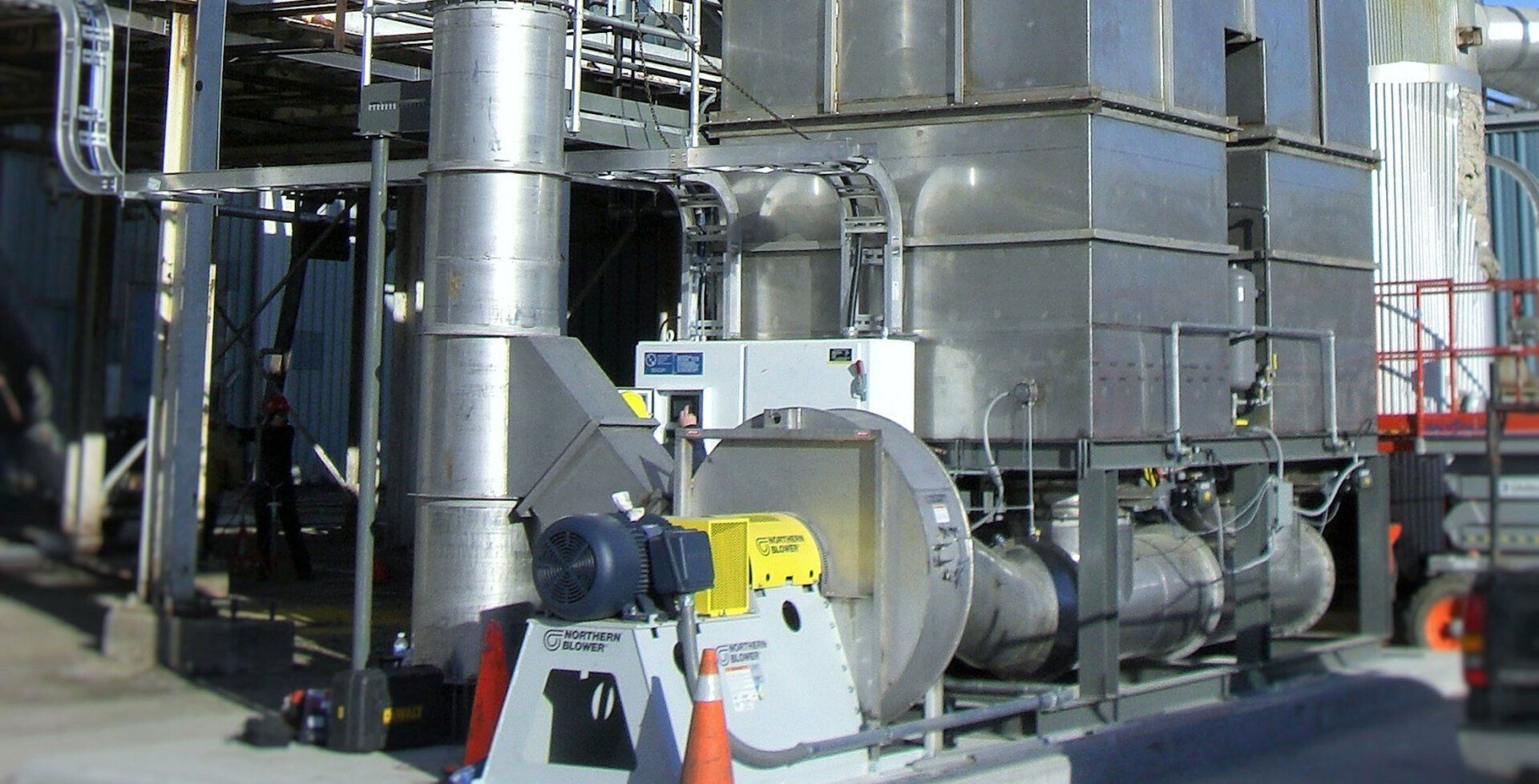 A large stainless steel building with a fan in front of it